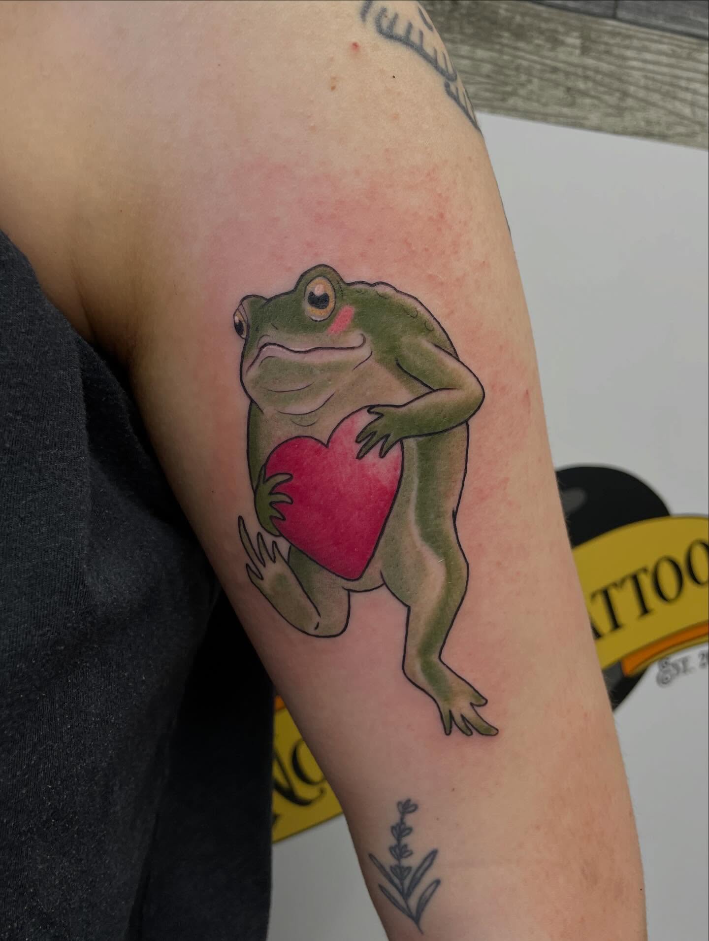 Frog holding heart realism tattoo on the forearm by Stevie Timmreck, Utica, Michigan