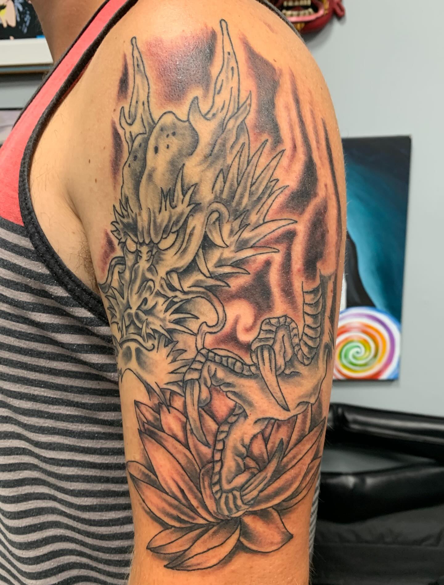 Dragon and lotus realism tattoo on the upper arm by @goat76