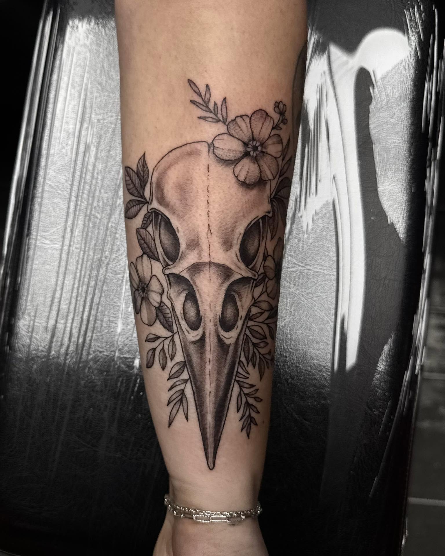 Bird skull with flowers realism tattoo on the forearm by Madison Jasso
