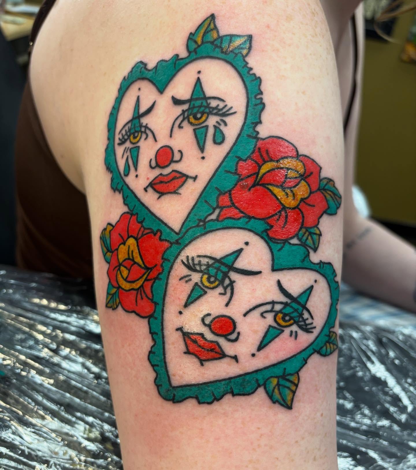 Clown faces American traditional tattoo on the upper arm by Natalie Opal🪻🍎🫖