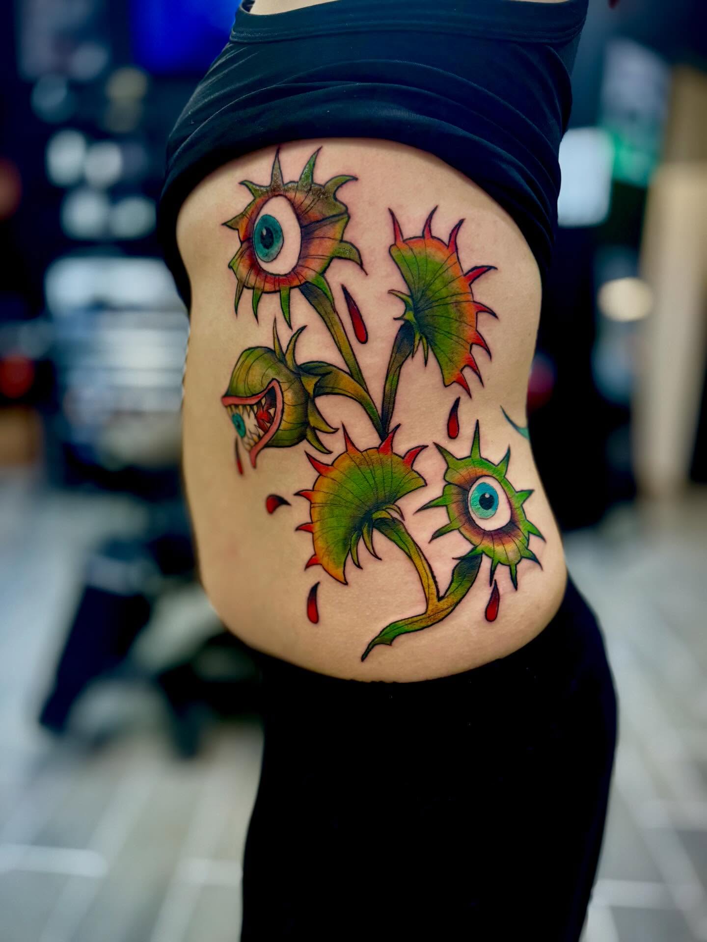 Eye flowers new school tattoo on the thigh by Katelyn Arnold