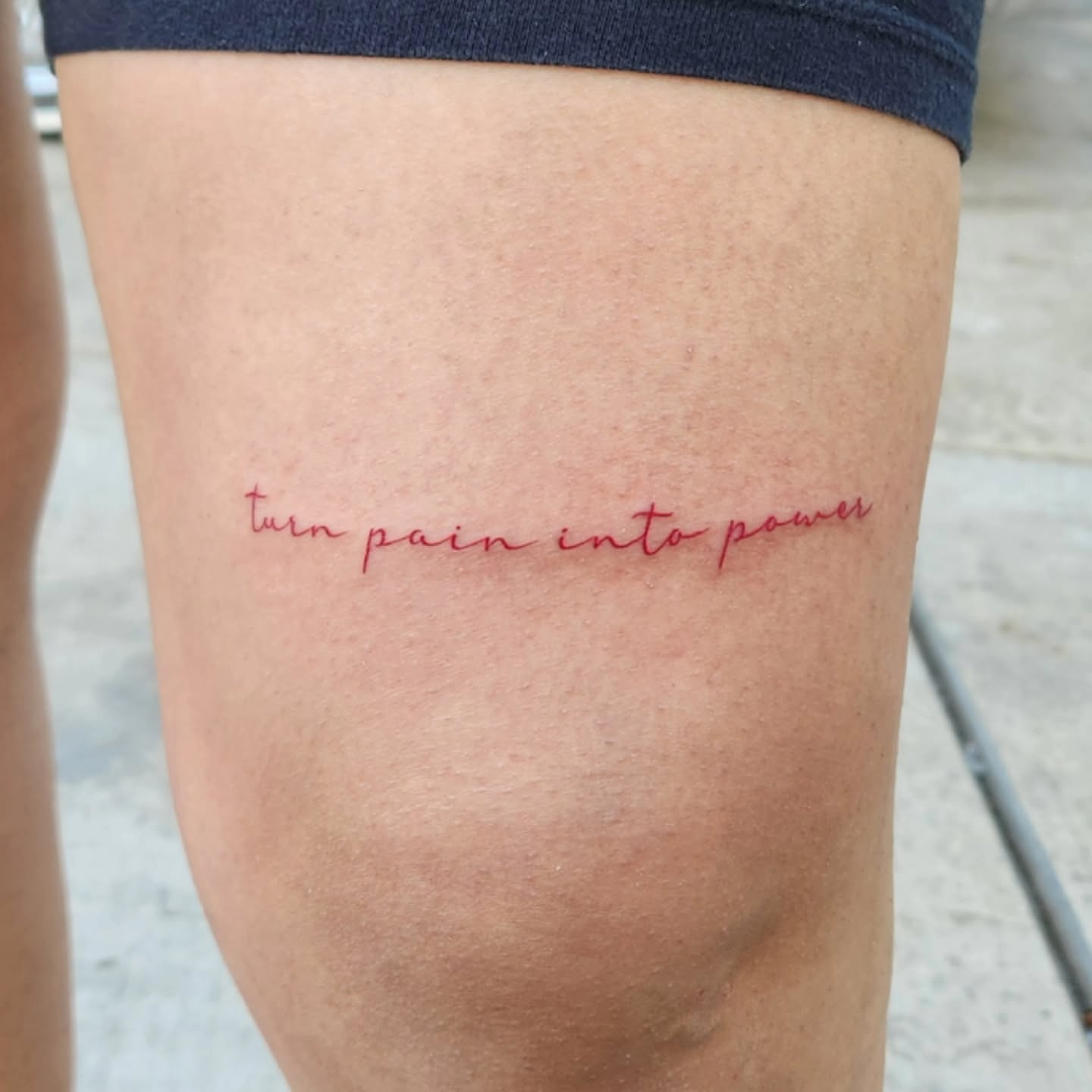 Turn pain into power lettering script tattoo on the thigh by @youxg_guxxz