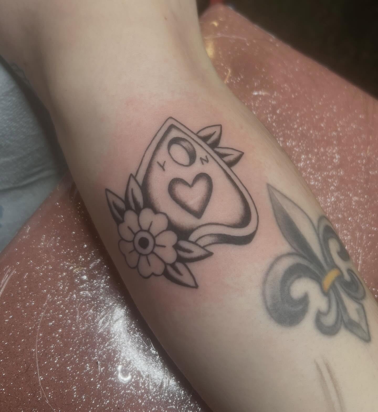 Playing card with heart American traditional tattoo on the forearm by Erika Donn, Portland, Oregon