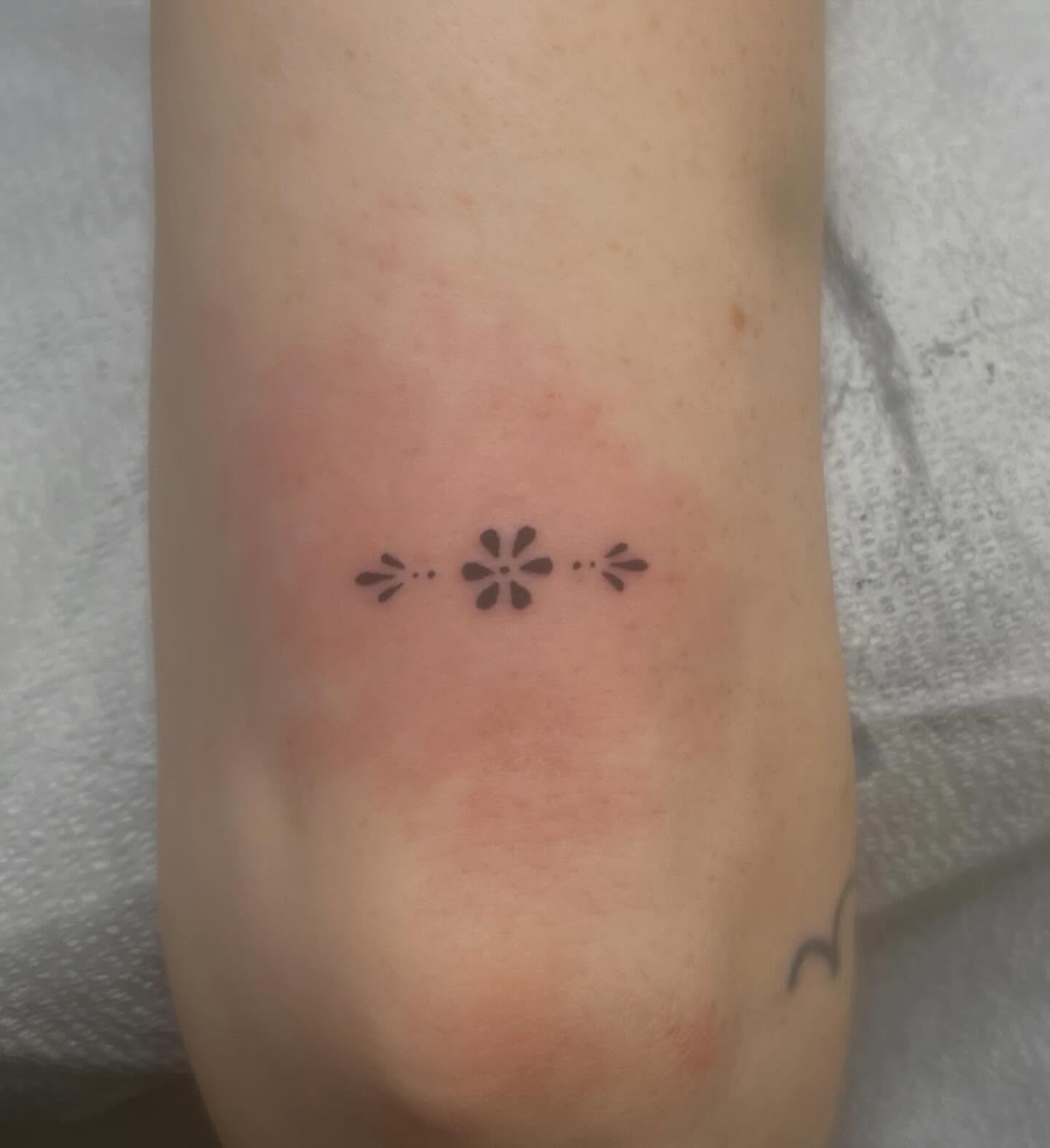 Three-pointed flower dotwork tattoo on the forearm by Erika Donn, Portland, Oregon