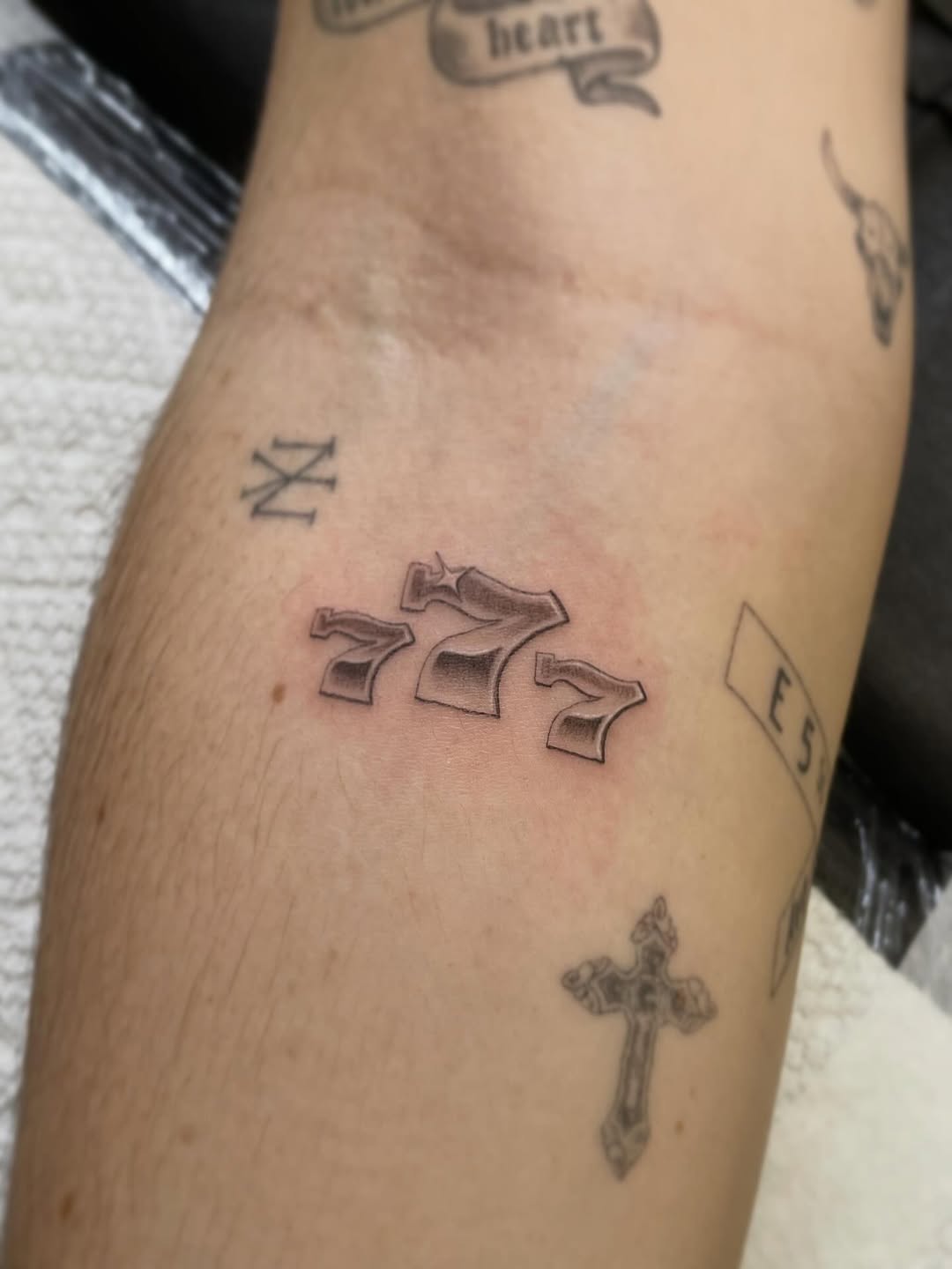 Lucky sevens minimalist tattoo on the forearm by Jesus A.
