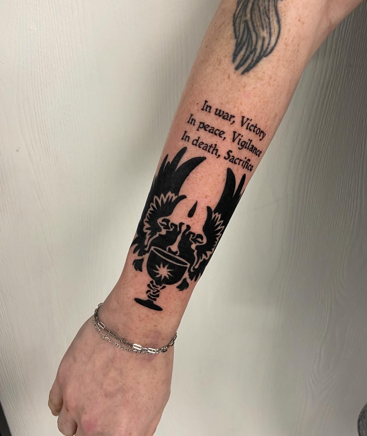 War quote black and grey tattoo on the forearm by Sophia