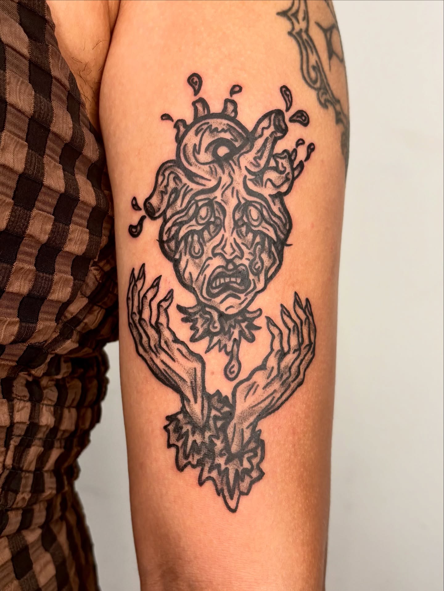 Heart with faces surrealism tattoo on the forearm by Grae