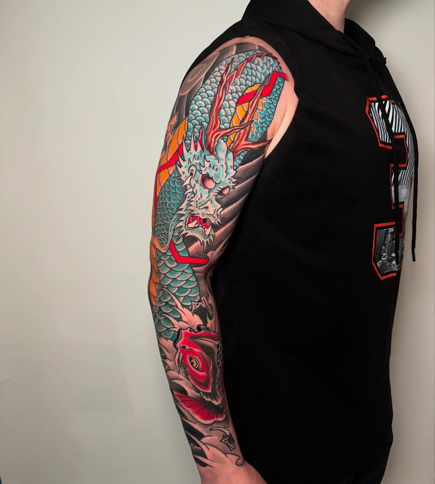 Dragon and koi fish japanese irezumi tattoo on the upper arm by Zac Chaffin