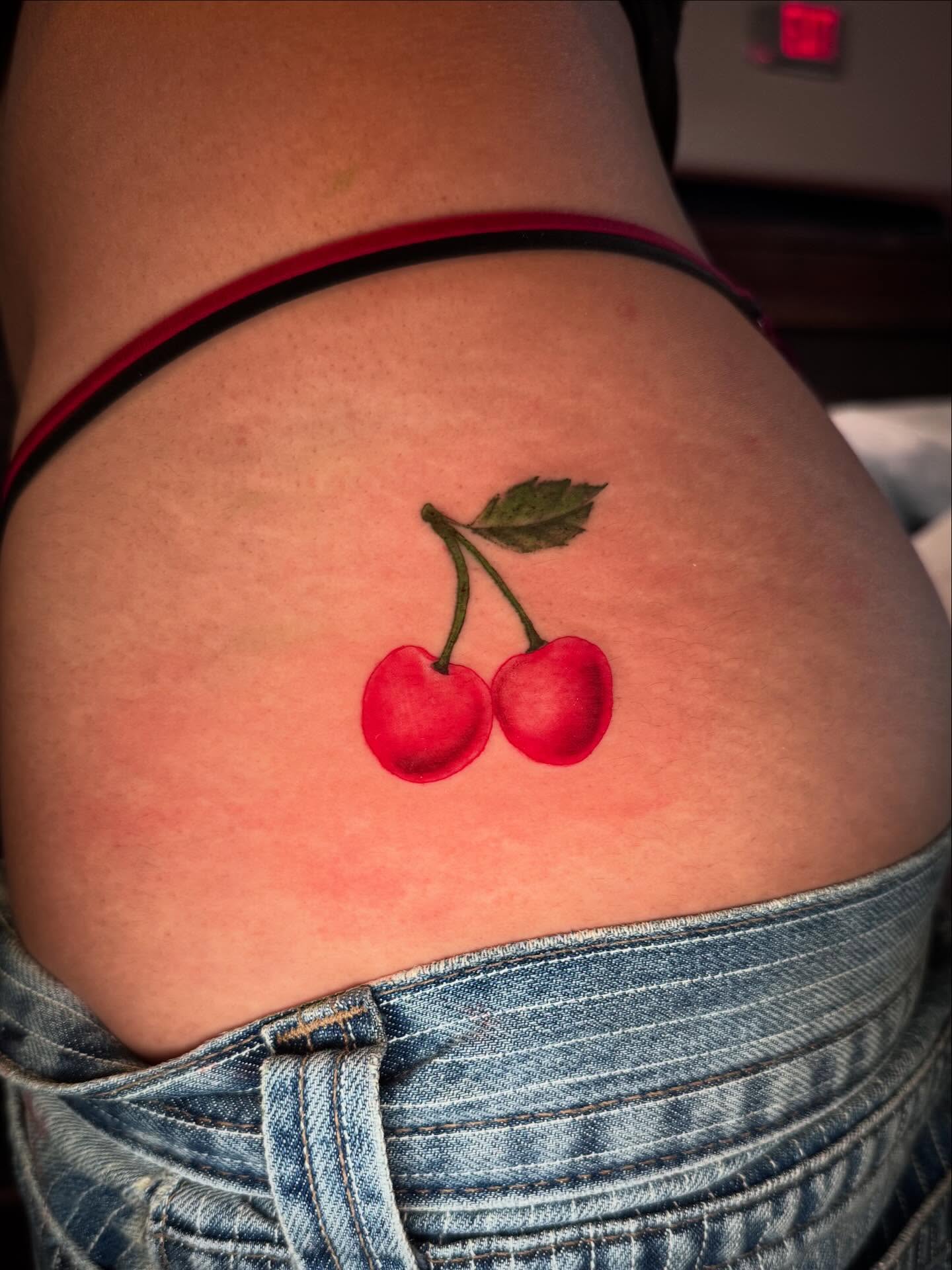 Cherries realism tattoo on the thigh by Gabrielle Mack