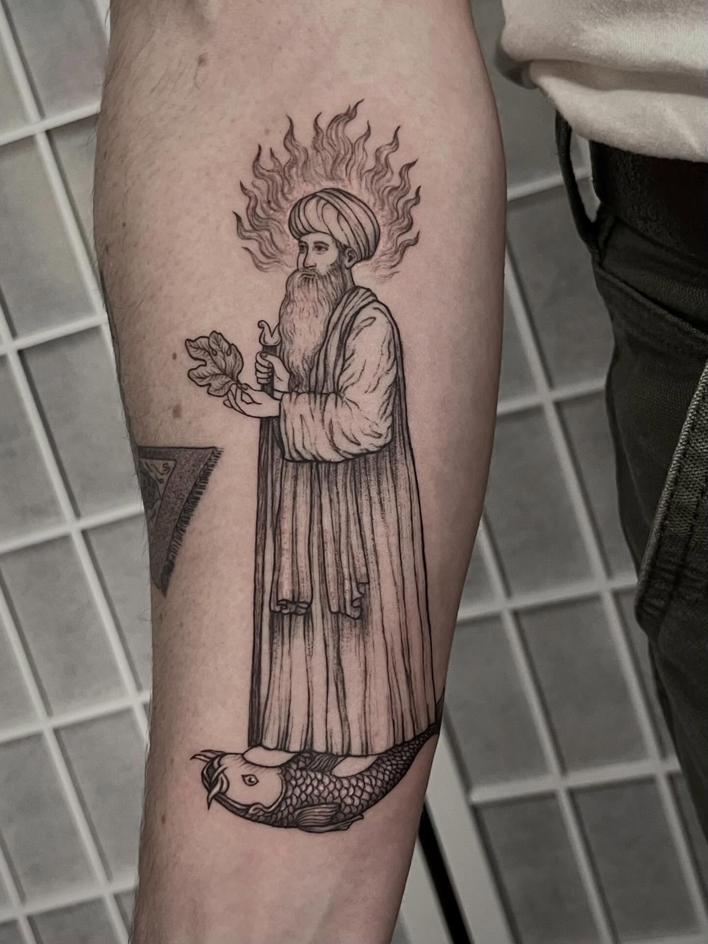 Saint with fish black and grey tattoo on the forearm by Tattoo Artist