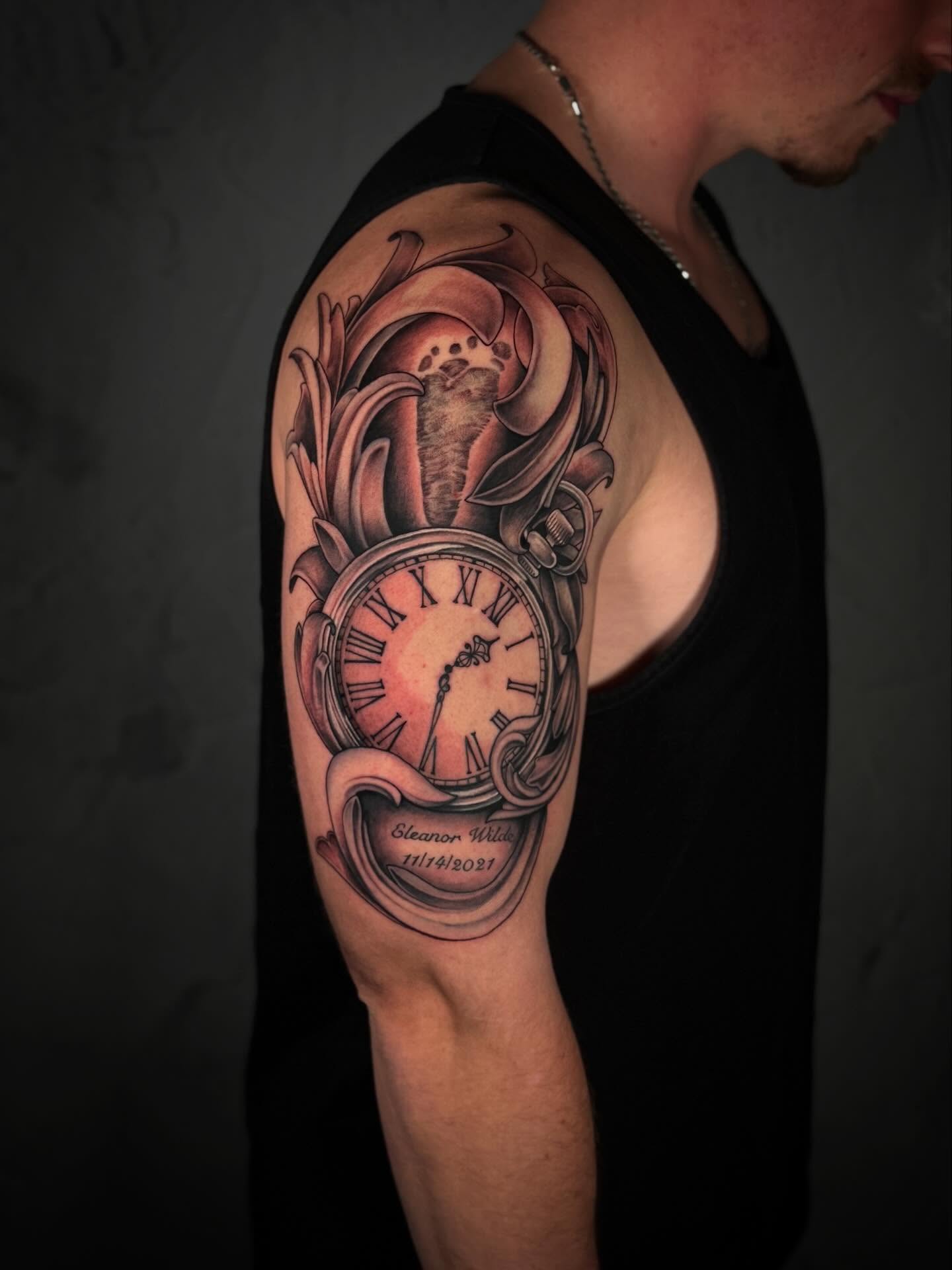 Clock and floral realism tattoo on the shoulder by Ethan Lund