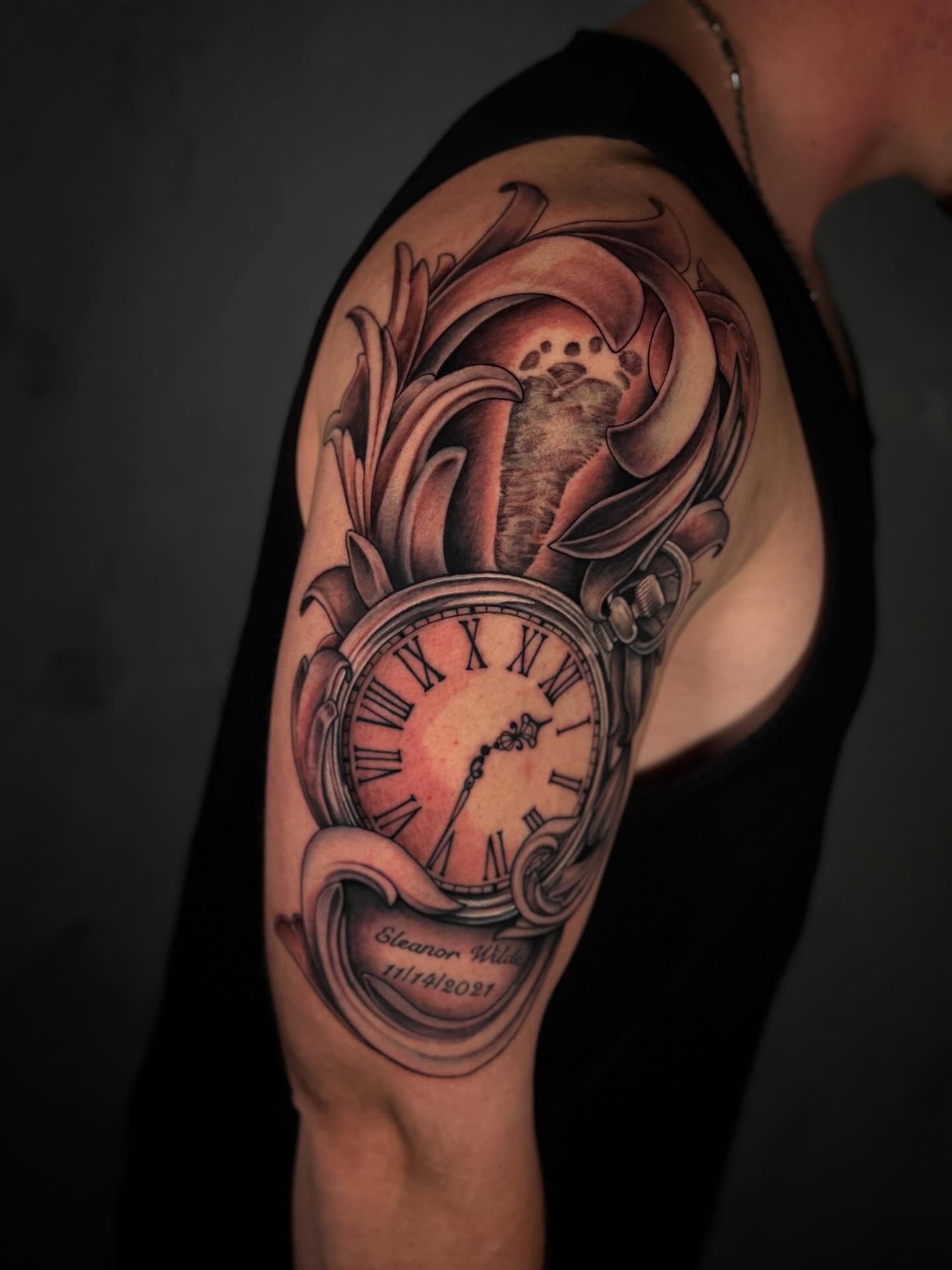 Clock and floral realism tattoo on the shoulder by Ethan Lund