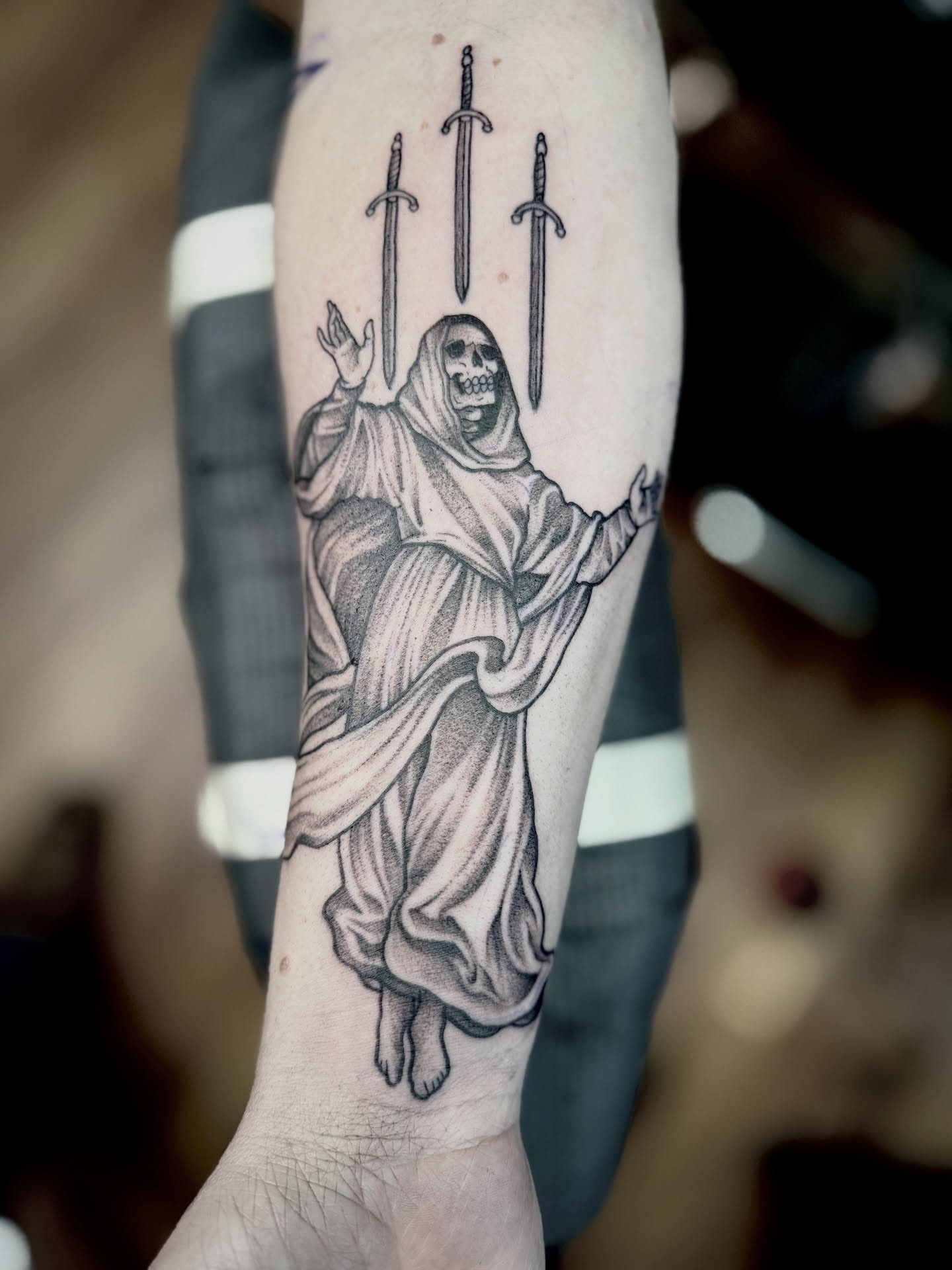 Reaper with swords realism tattoo on the forearm by Jeremy Utley