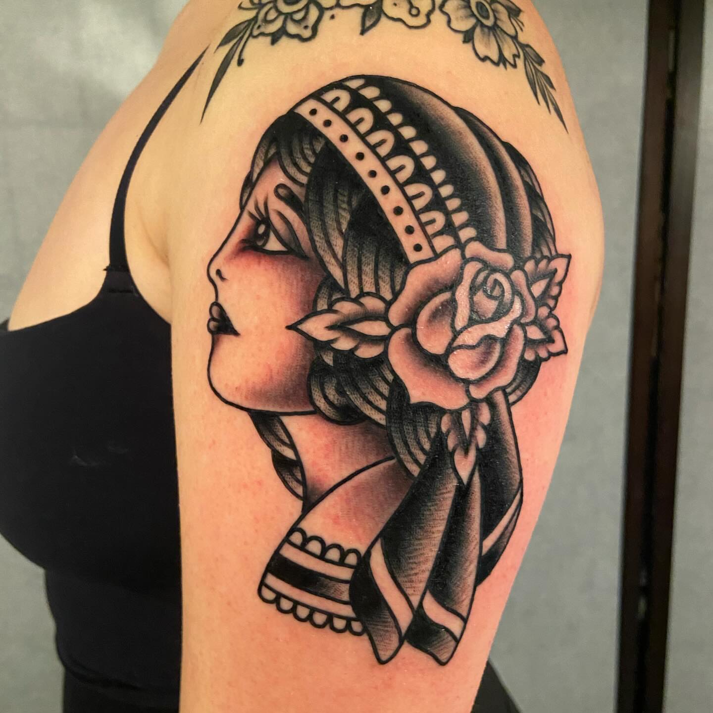 Woman with floral crown American traditional tattoo on the shoulder by Anthony Jaeger, Seattle, Washington