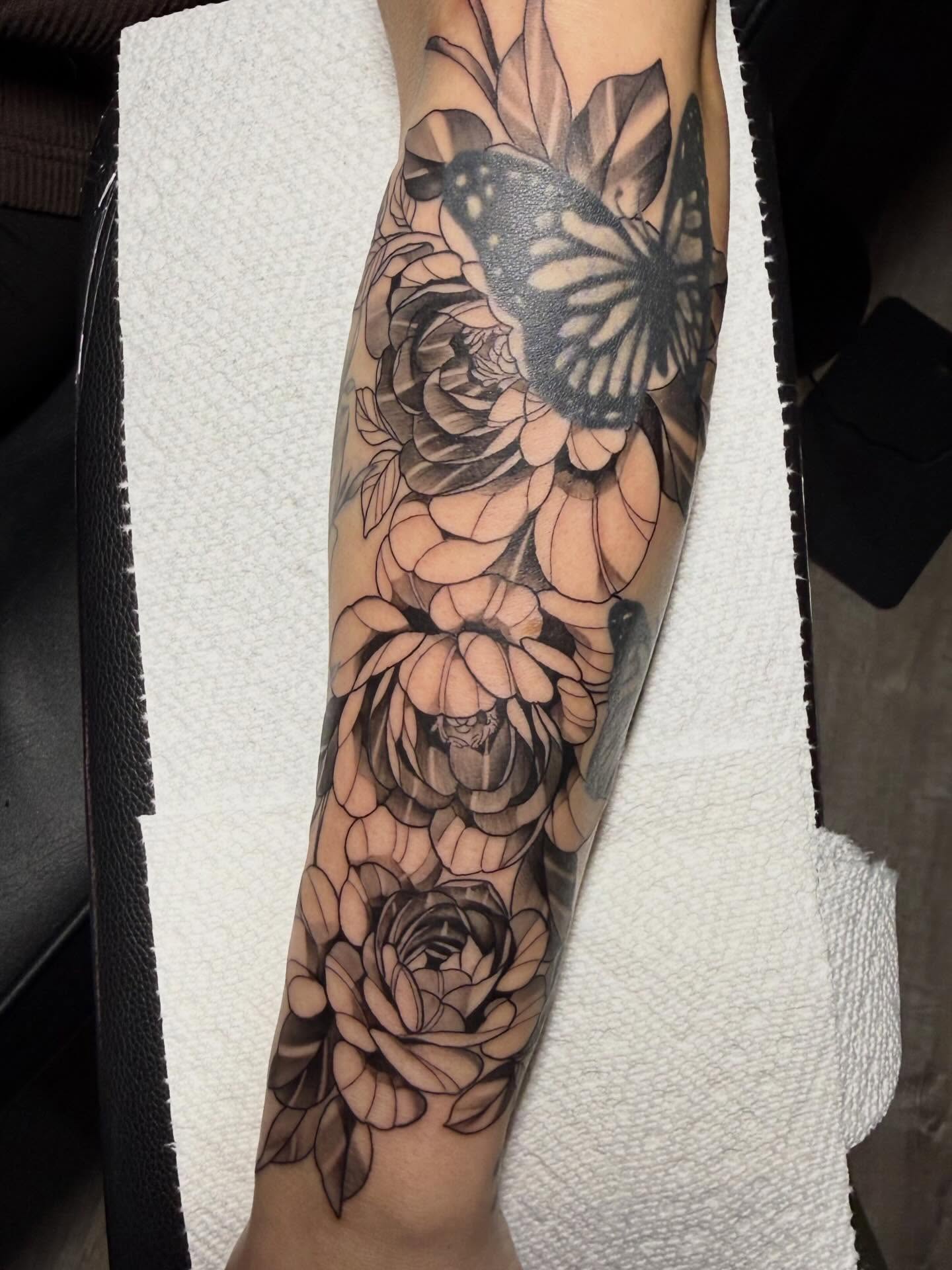 Flowers and butterfly realism tattoo on the forearm by Diana Guillette