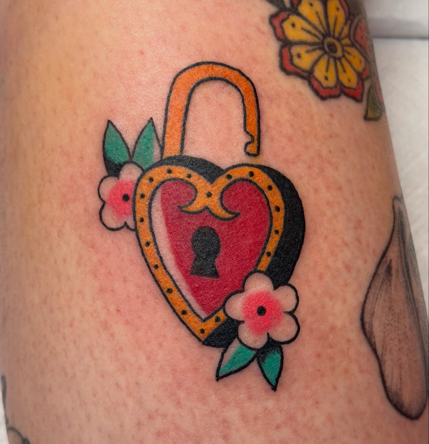 Heart-shaped lock American traditional tattoo on the forearm by Kelsey Turnis