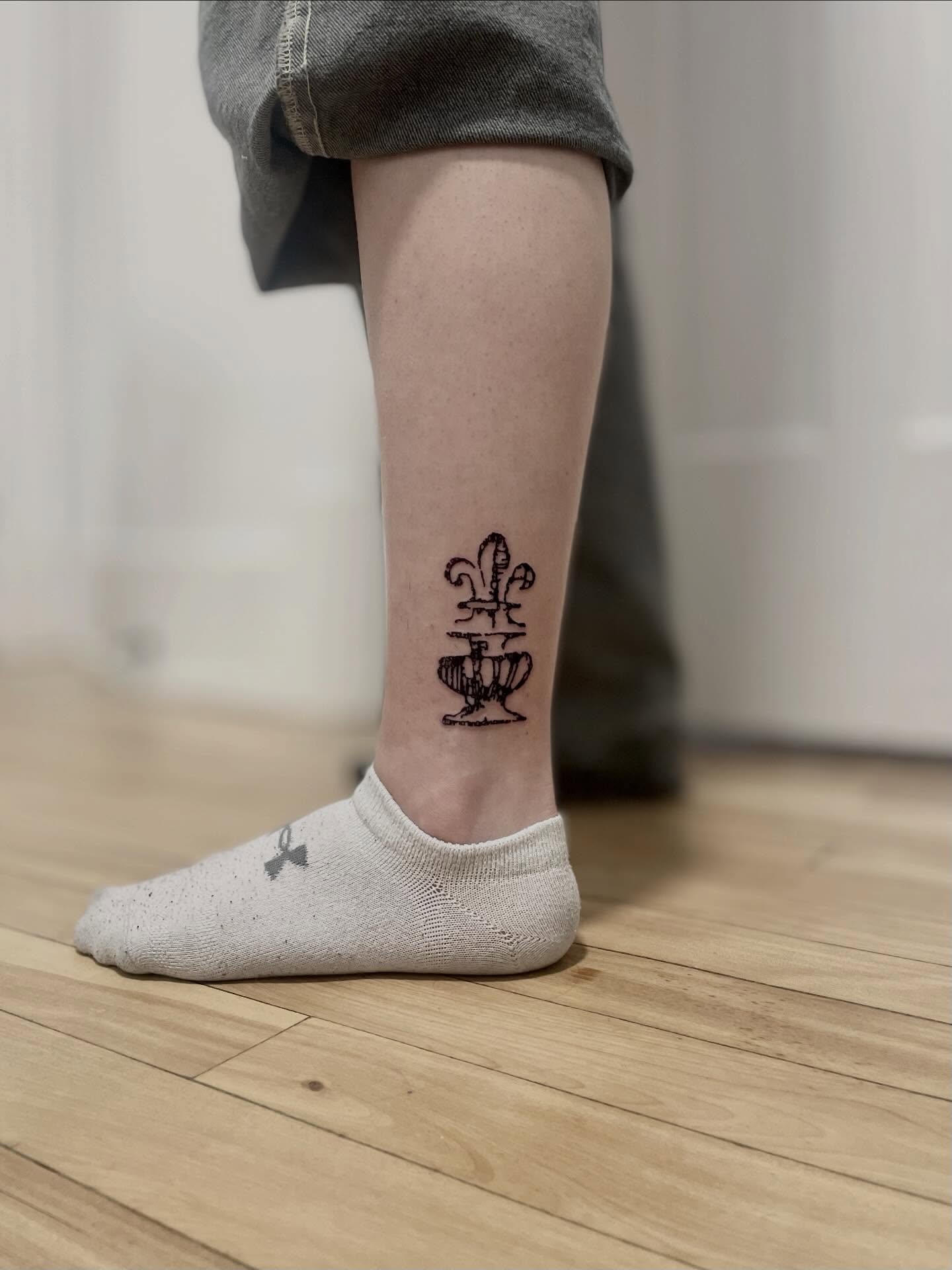 Fleur-de-lis and cup black and grey tattoo on the calf by barto