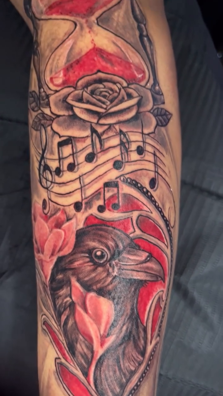 Raven with hourglass and musical notes realism tattoo on the forearm by Jakobi