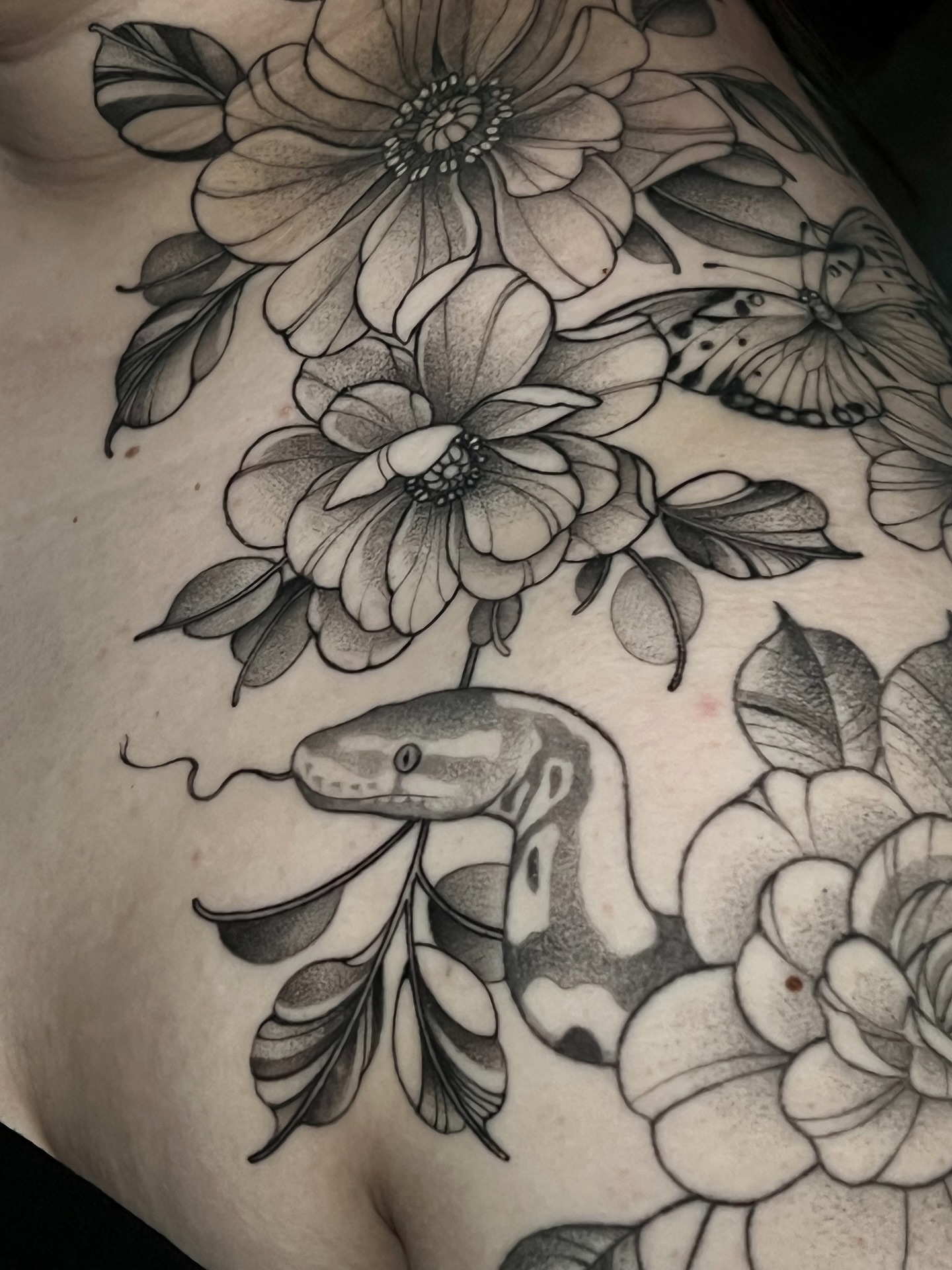 Snake and flowers realism tattoo on the chest by Tehnaya