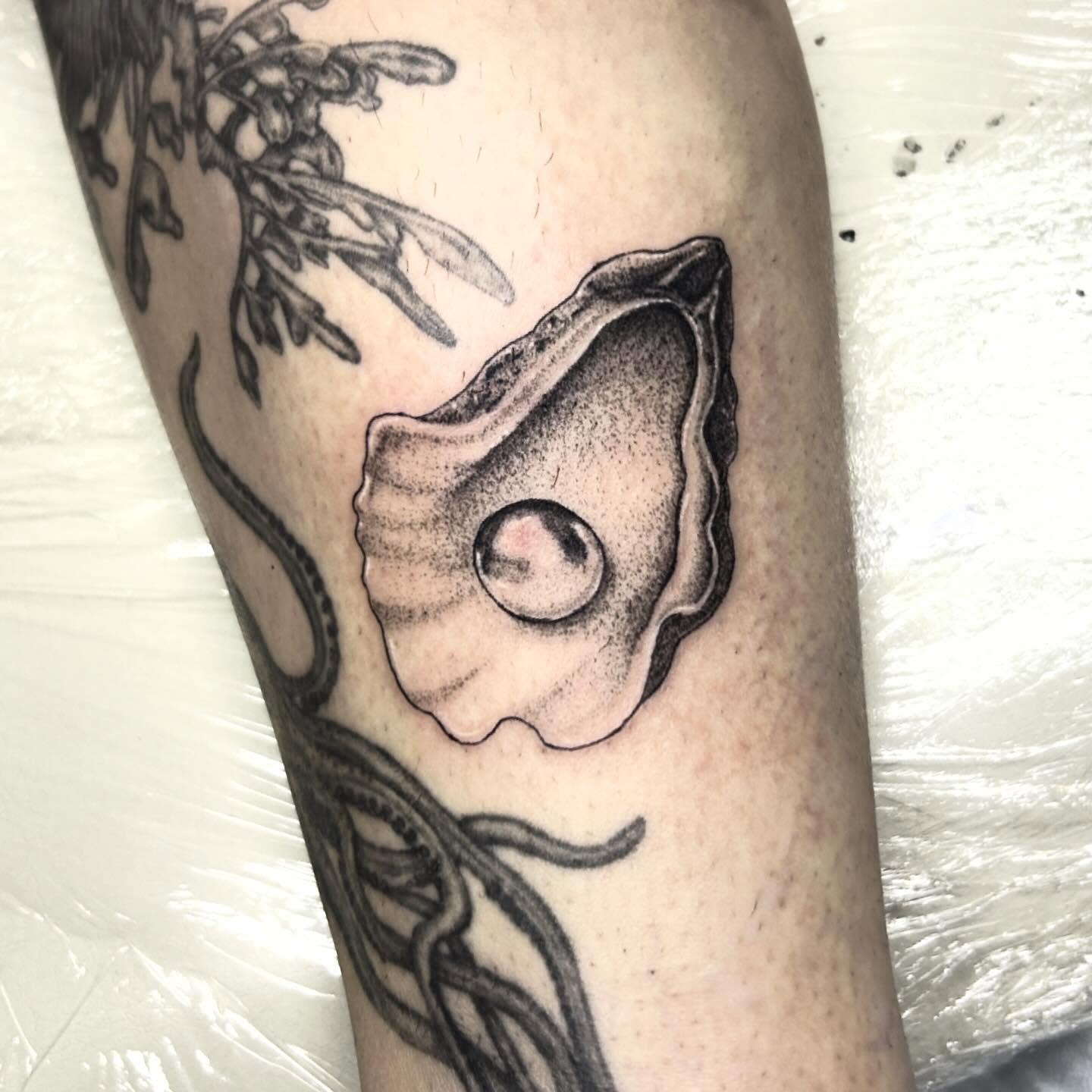 Oyster shell with pearl dotwork tattoo on the forearm by Nikki Power