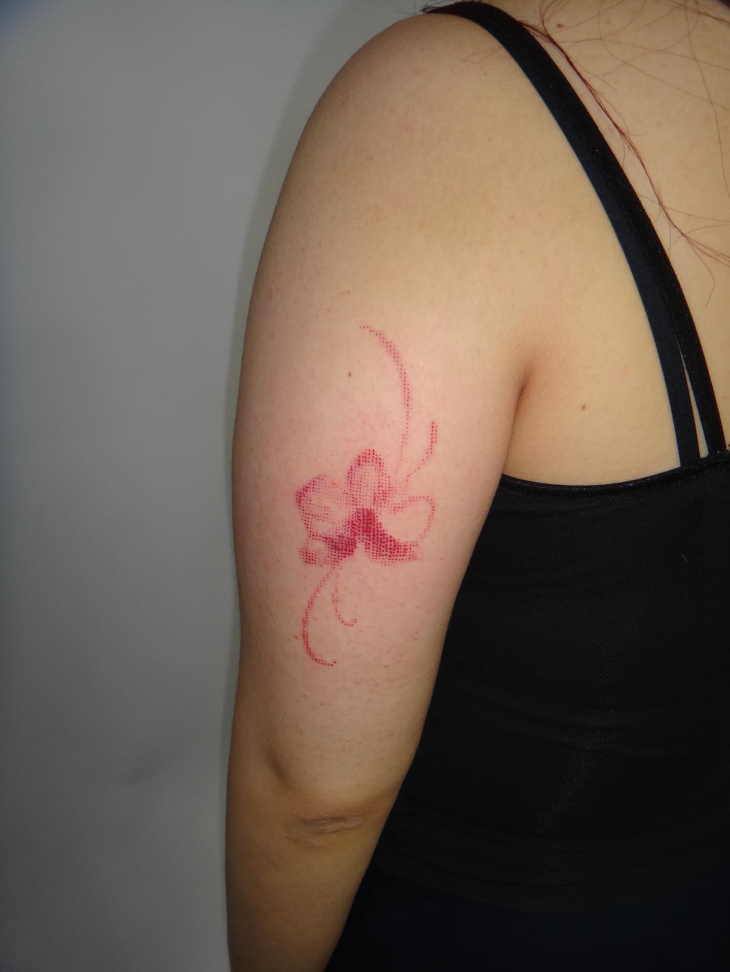 Orchid dotwork tattoo on the upper arm by Nevaeh tattoo artist