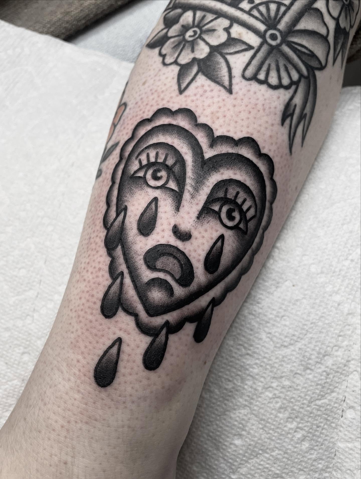 Heart with crying eyes American traditional tattoo on the forearm by Kat, Sacramento, California