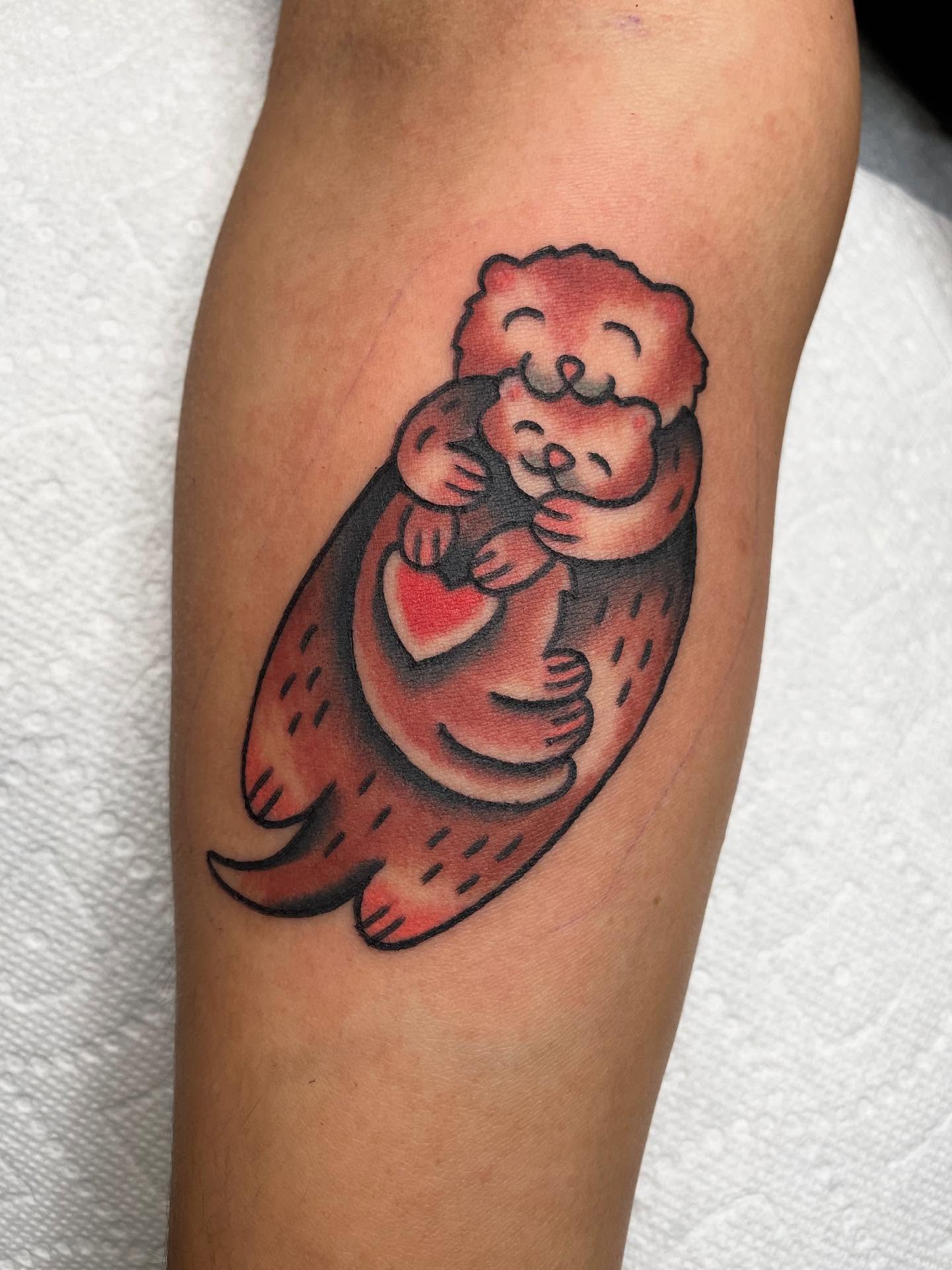 Hugging otters American traditional tattoo on the forearm by Kat, Sacramento, California