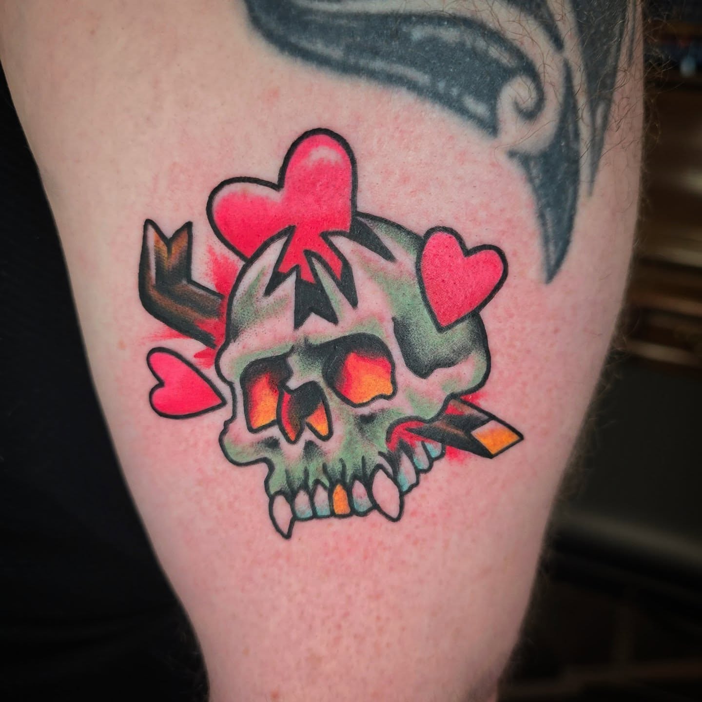 Skull with hearts American traditional tattoo on the thigh by Joseph Jeffers