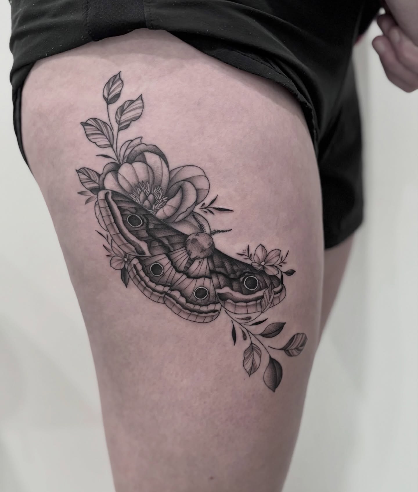 Butterfly and flower realism tattoo on the thigh by Elise Lamoureux- Tattoo Artist, Airdrie, Alberta
