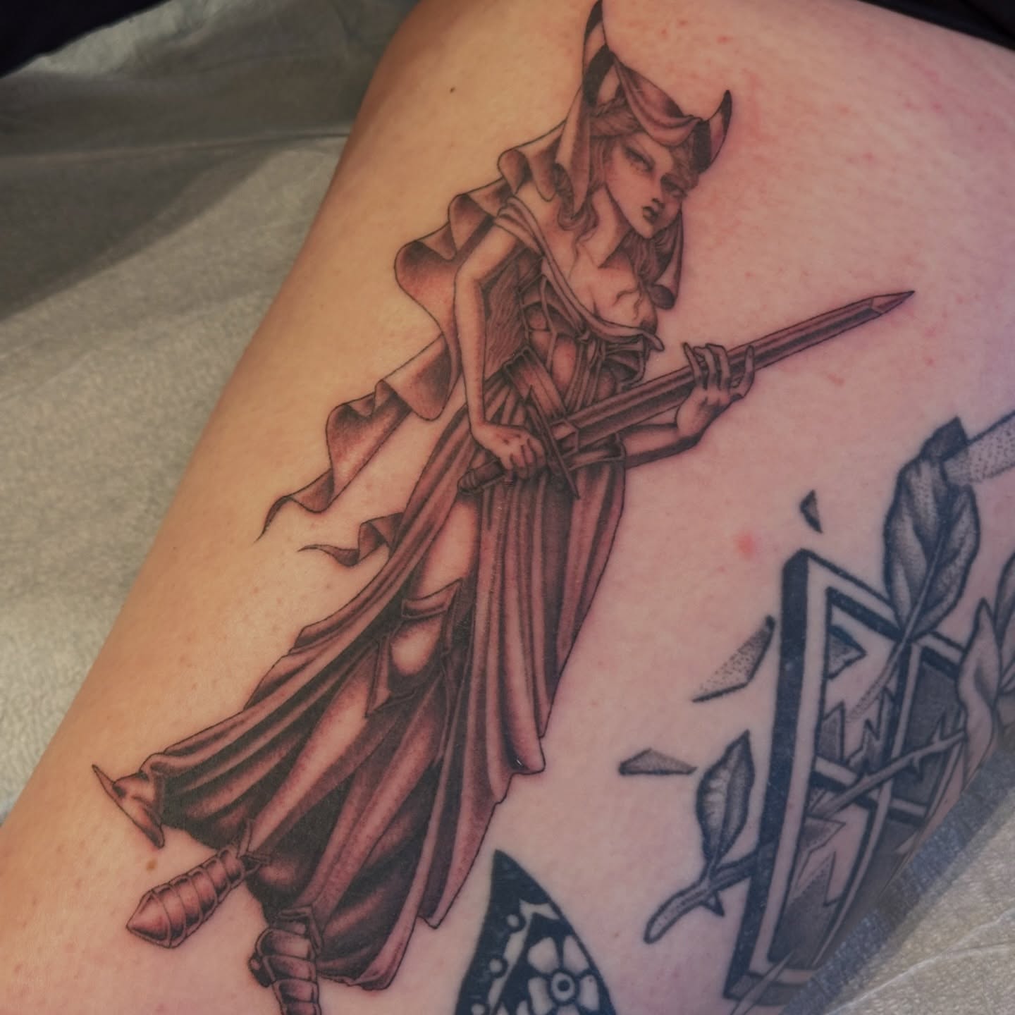 Female warrior black and grey tattoo on the thigh by Bree Lin