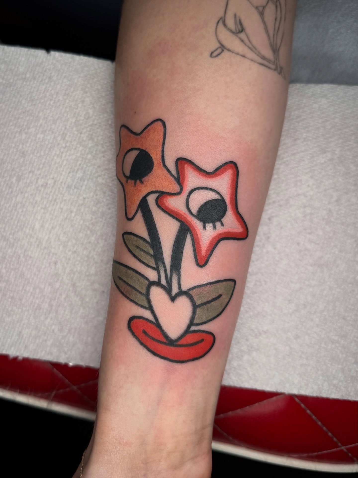 Flower and star American traditional tattoo on the forearm by lily gustave i tattoo