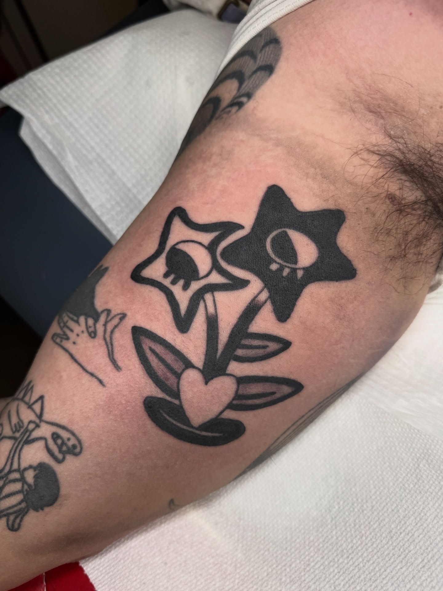 Star and heart black and grey tattoo on the forearm by lily gustave i tattoo