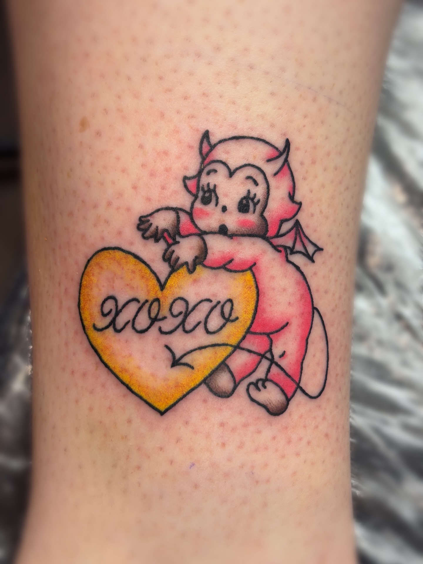 Cupid with heart American traditional tattoo on the forearm by Bree Burgess