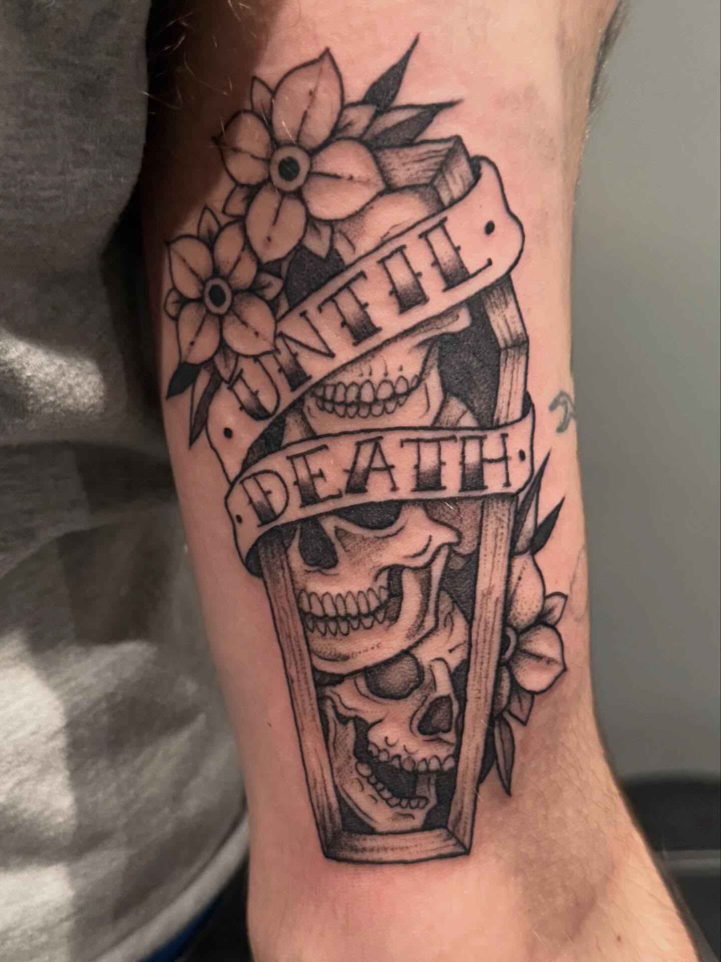 Skulls and flowers realism tattoo on the forearm by Courtney