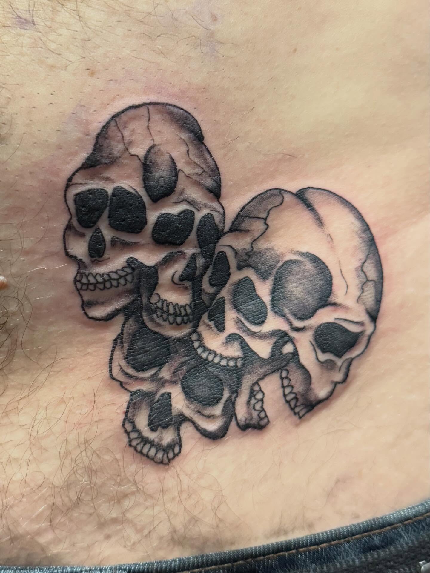 Skulls black and grey tattoo on the chest by Courtney