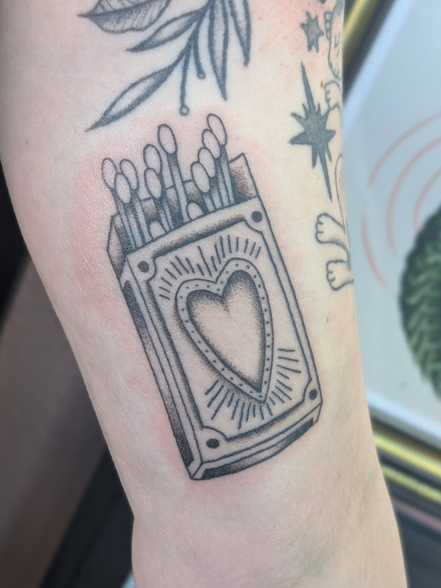 Matches and heart black and grey tattoo on the forearm by Alexandria Green