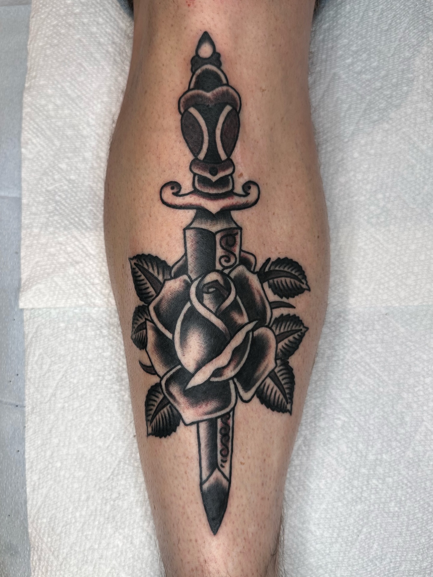Knife and rose American traditional tattoo on the forearm by Brock Johnson
