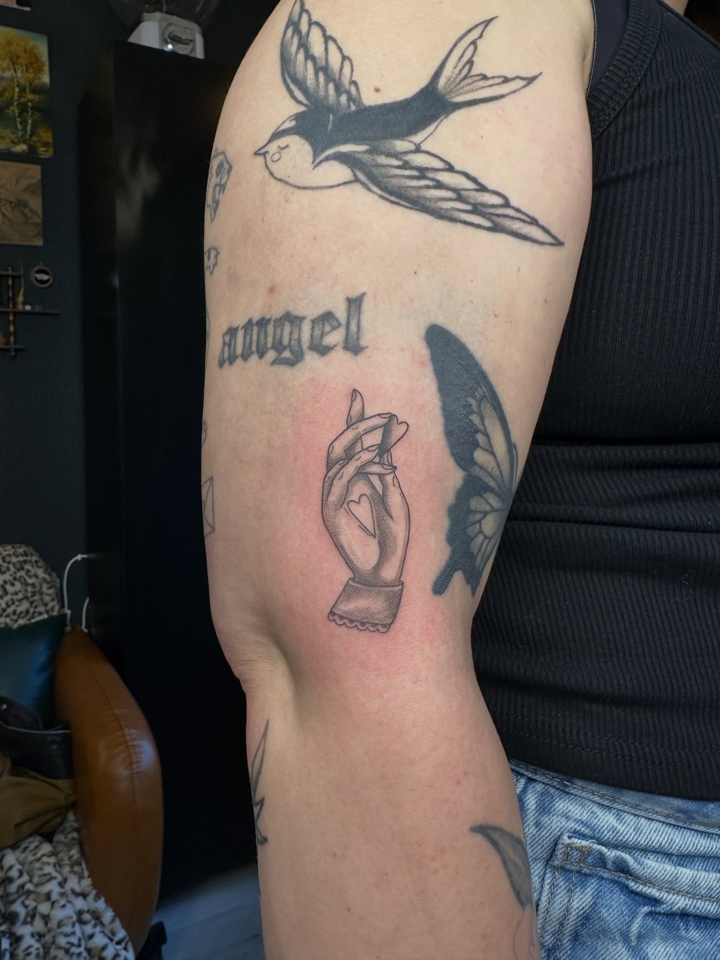 Swallow and butterfly black and grey tattoo on the forearm by Emma Thompson