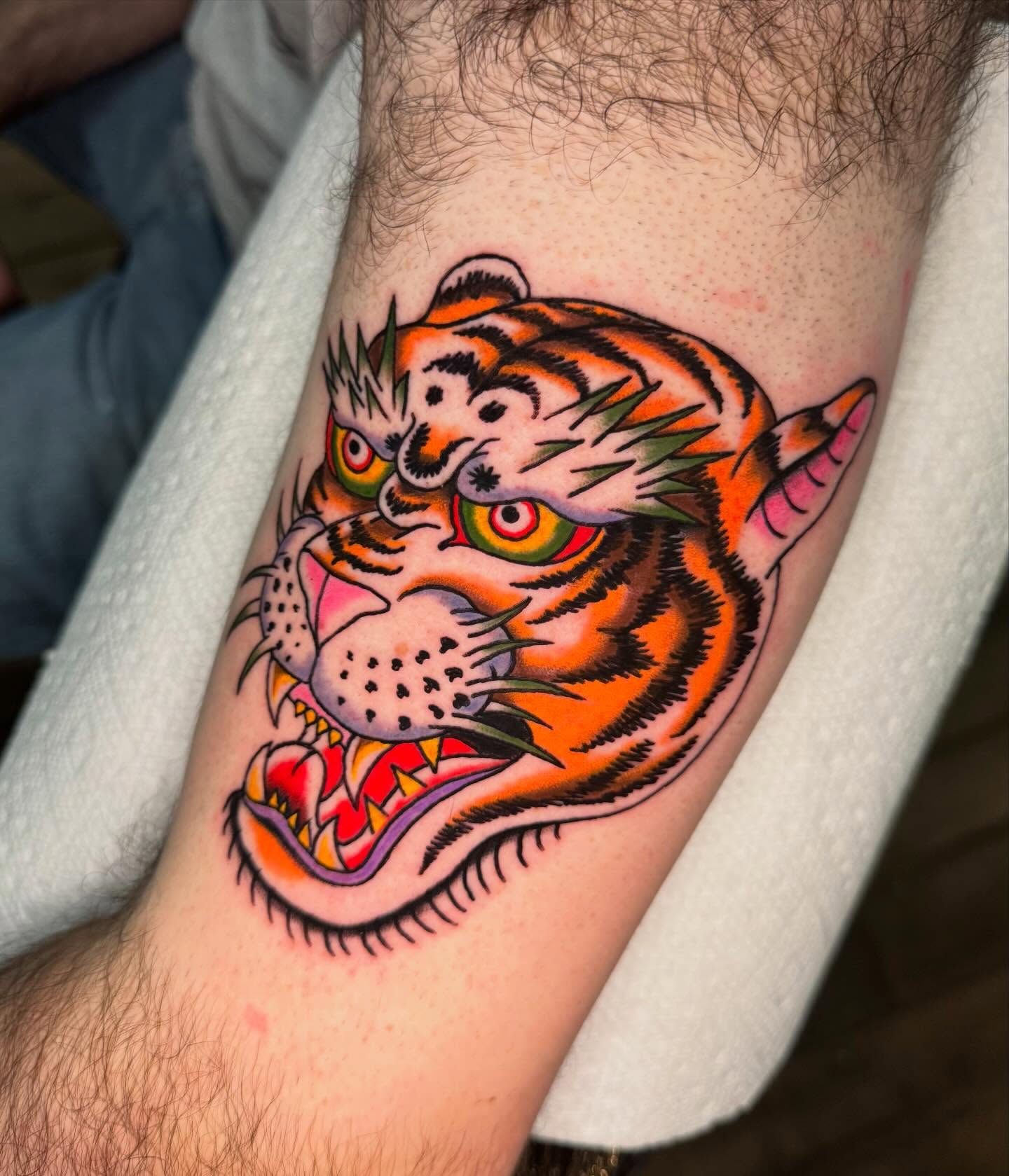 Tiger head American traditional tattoo on the forearm by @michaelryan_tattoo