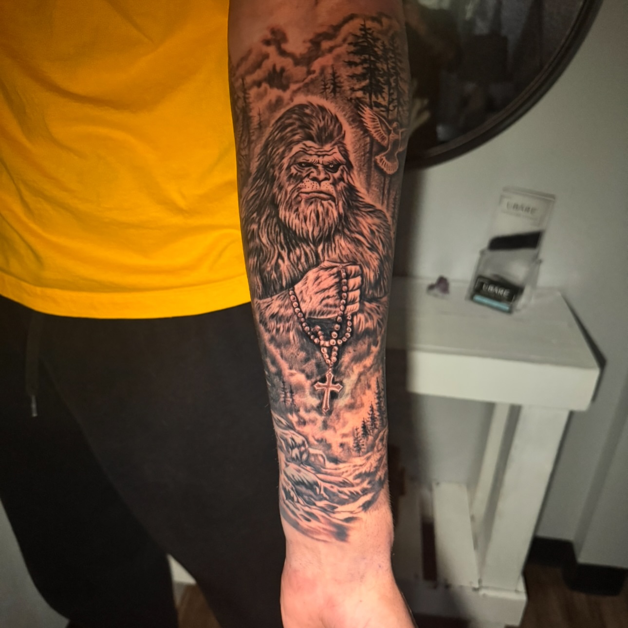 Bigfoot praying realism tattoo on the forearm by Tampa tattoo artist