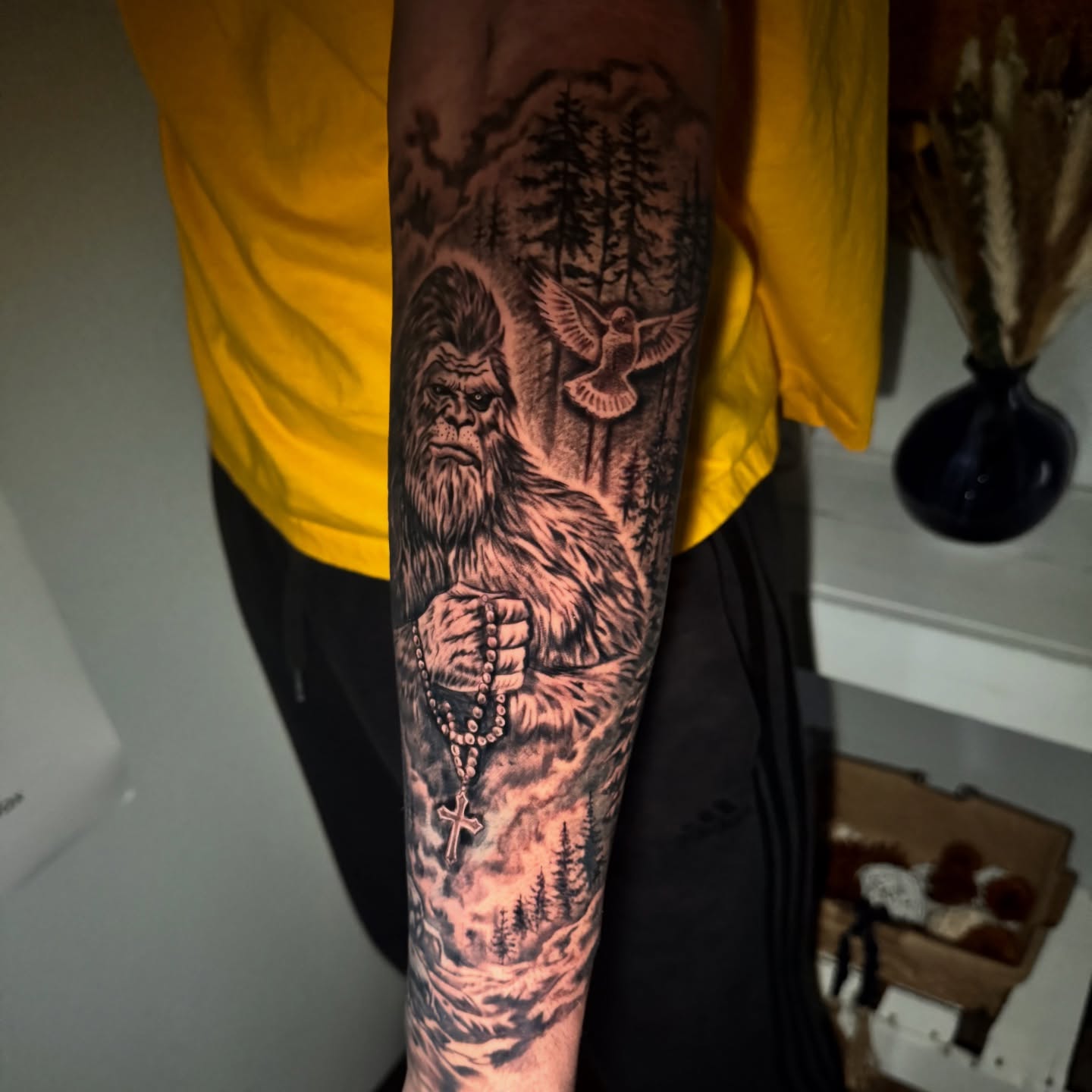 Bigfoot with rosary realism tattoo on the forearm by Tampa tattoo artist