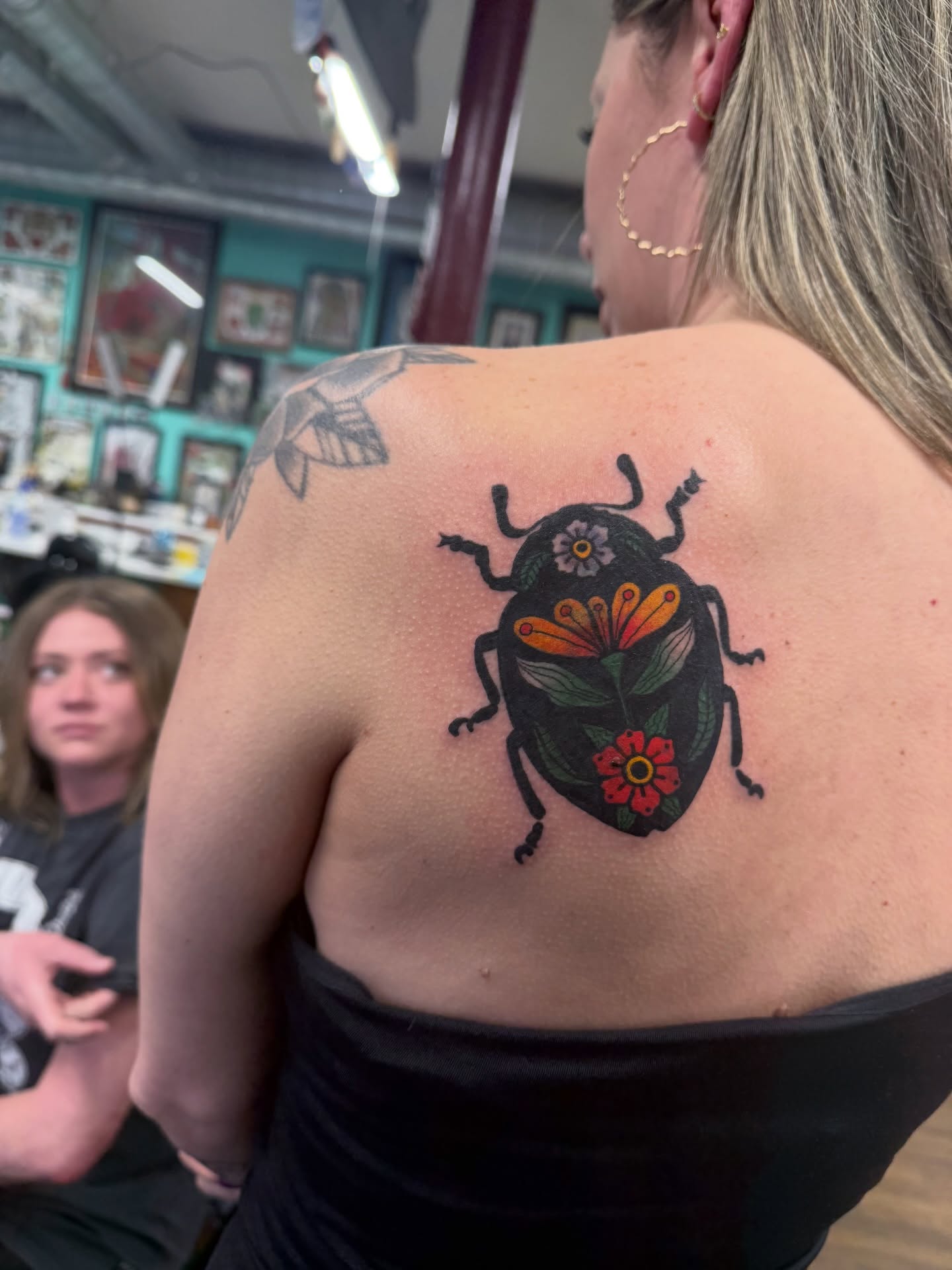 Beetle with flowers American traditional tattoo on the shoulder by Aaron ulfstam