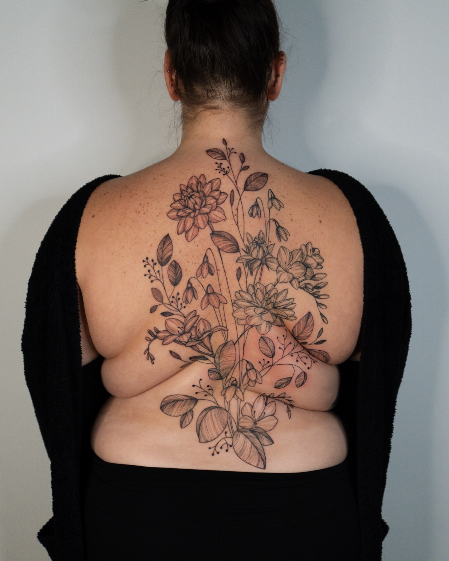 Floral bouquet black and grey tattoo on the back by Mikayla Sue