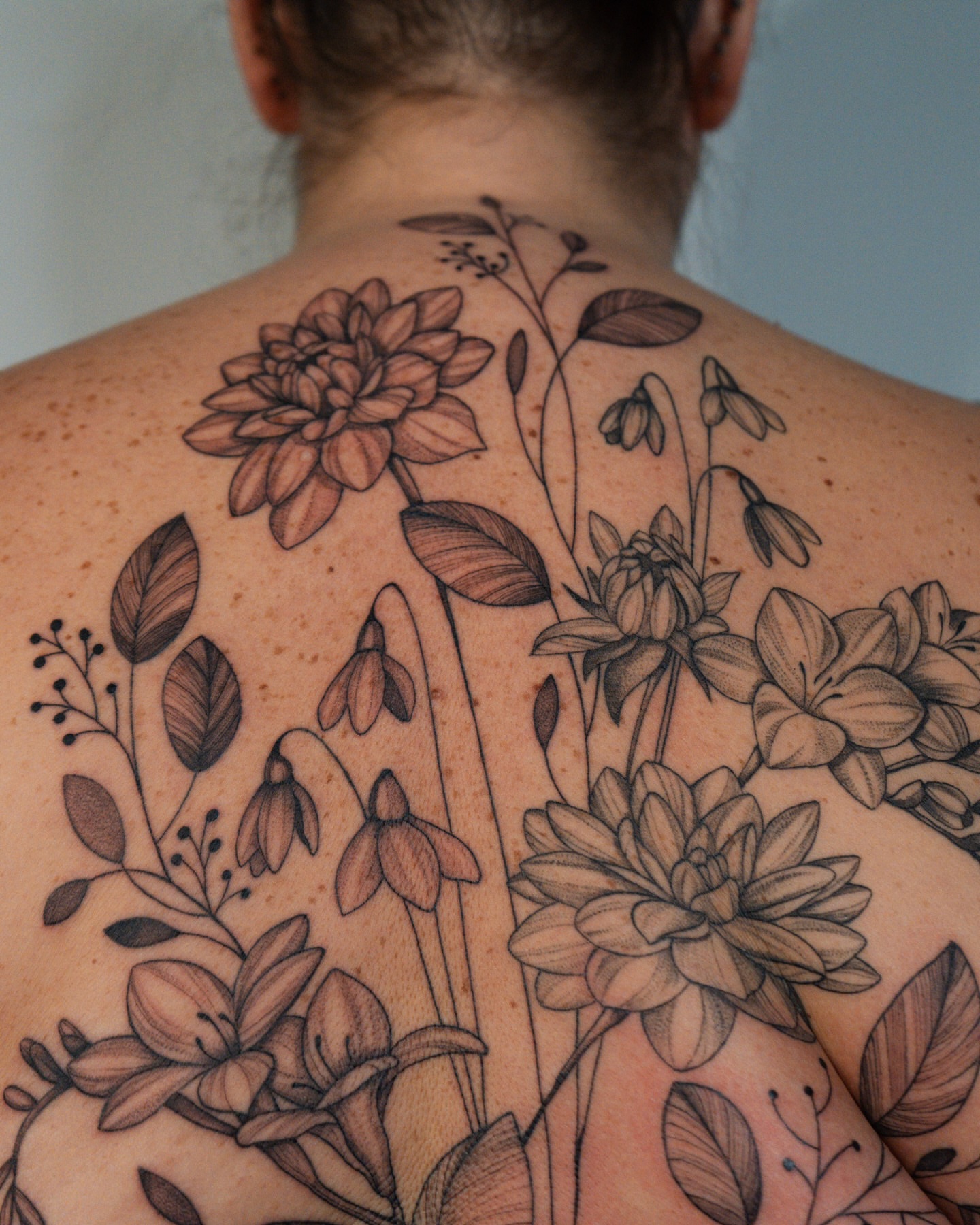 Floral bouquet black and grey tattoo on the back by Mikayla Sue