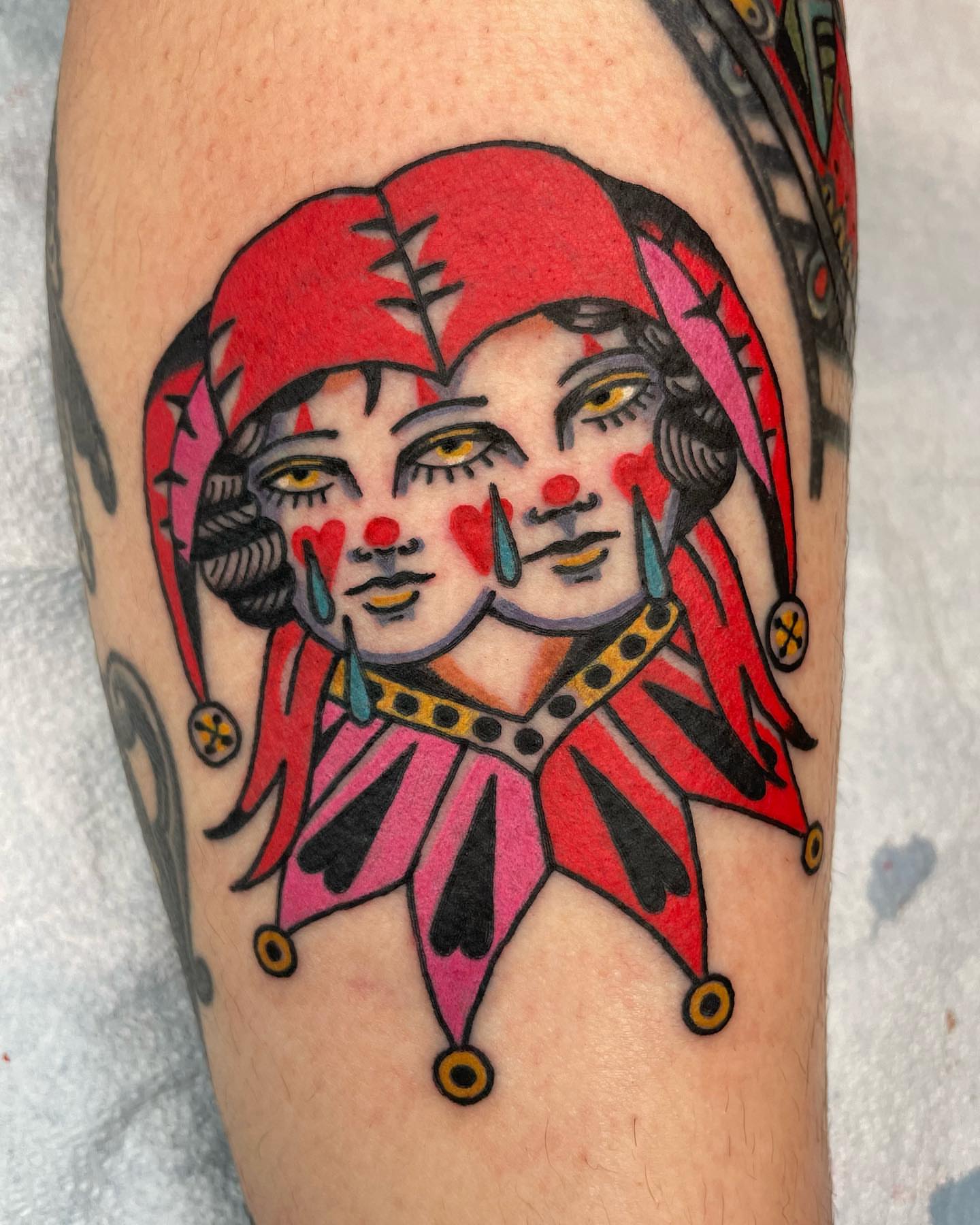 Jester faces American traditional tattoo on the forearm by Gerald Bellmore