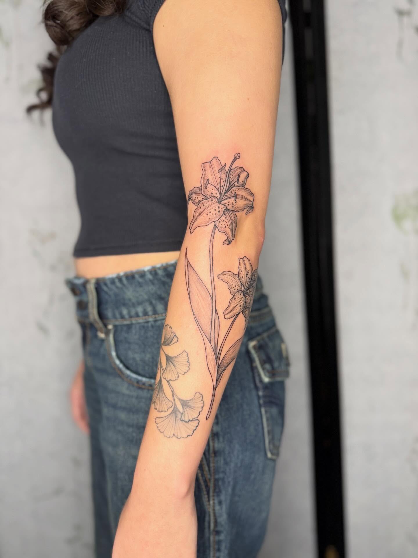 Lily black and grey tattoo on the forearm by Noelle Adrienne Tattoos