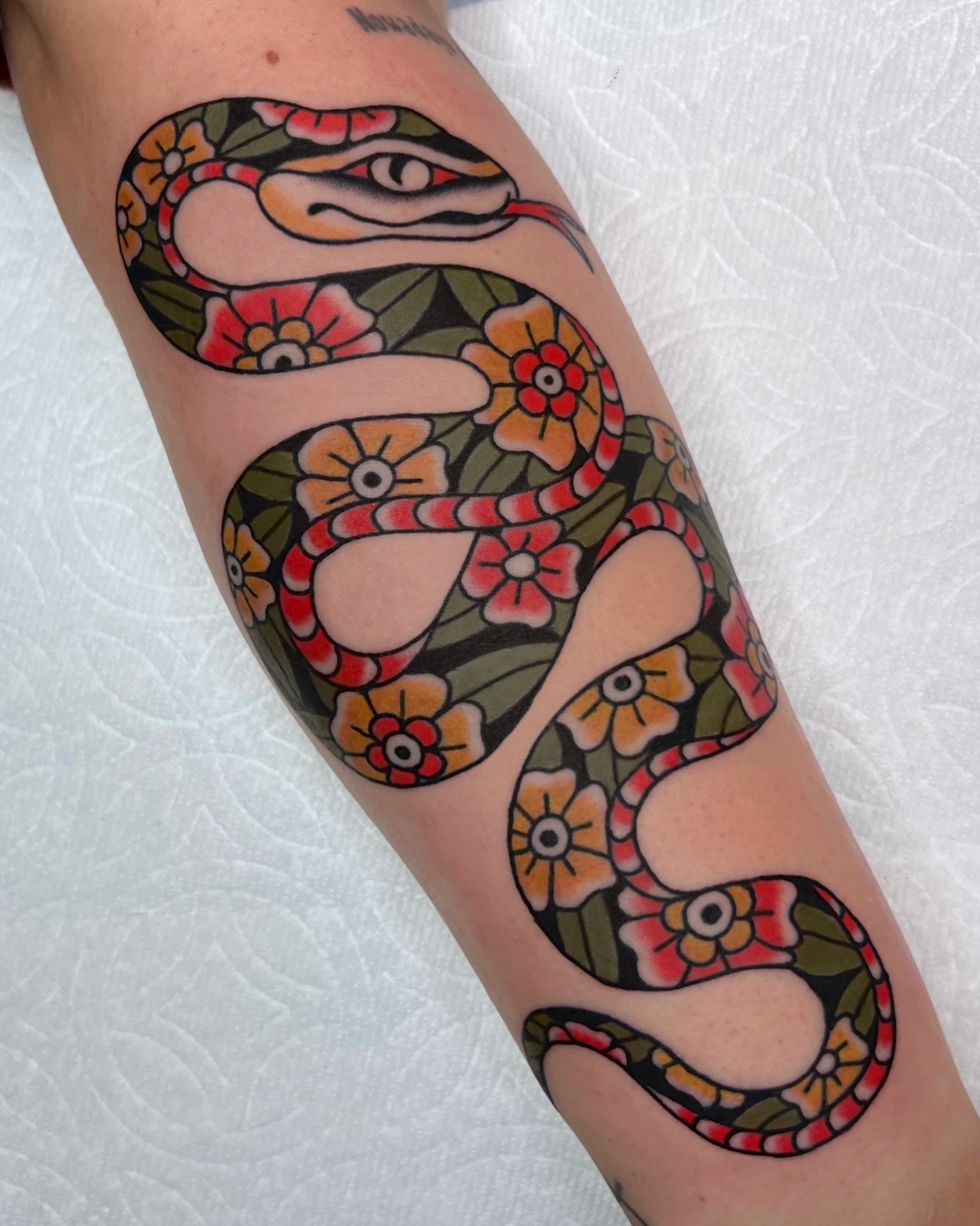 Snake and floral pattern American traditional tattoo on the forearm by Brian Visser