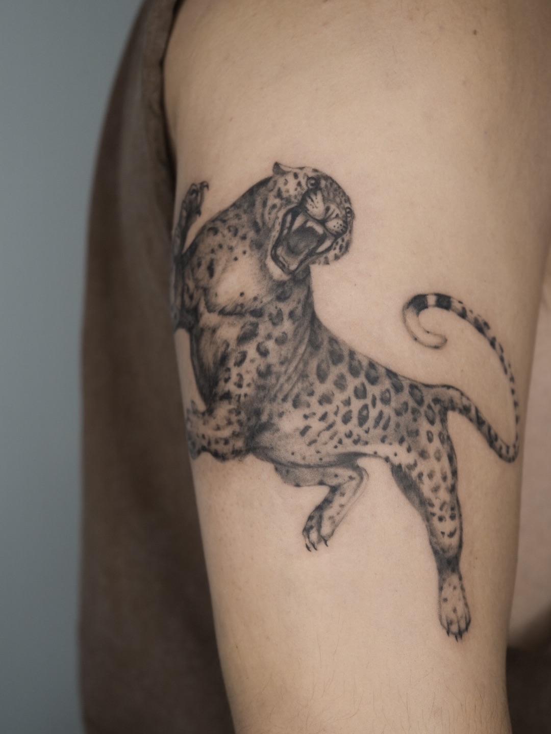 Leopard black and grey tattoo on the forearm by Blackwork & microrealism tattoos
