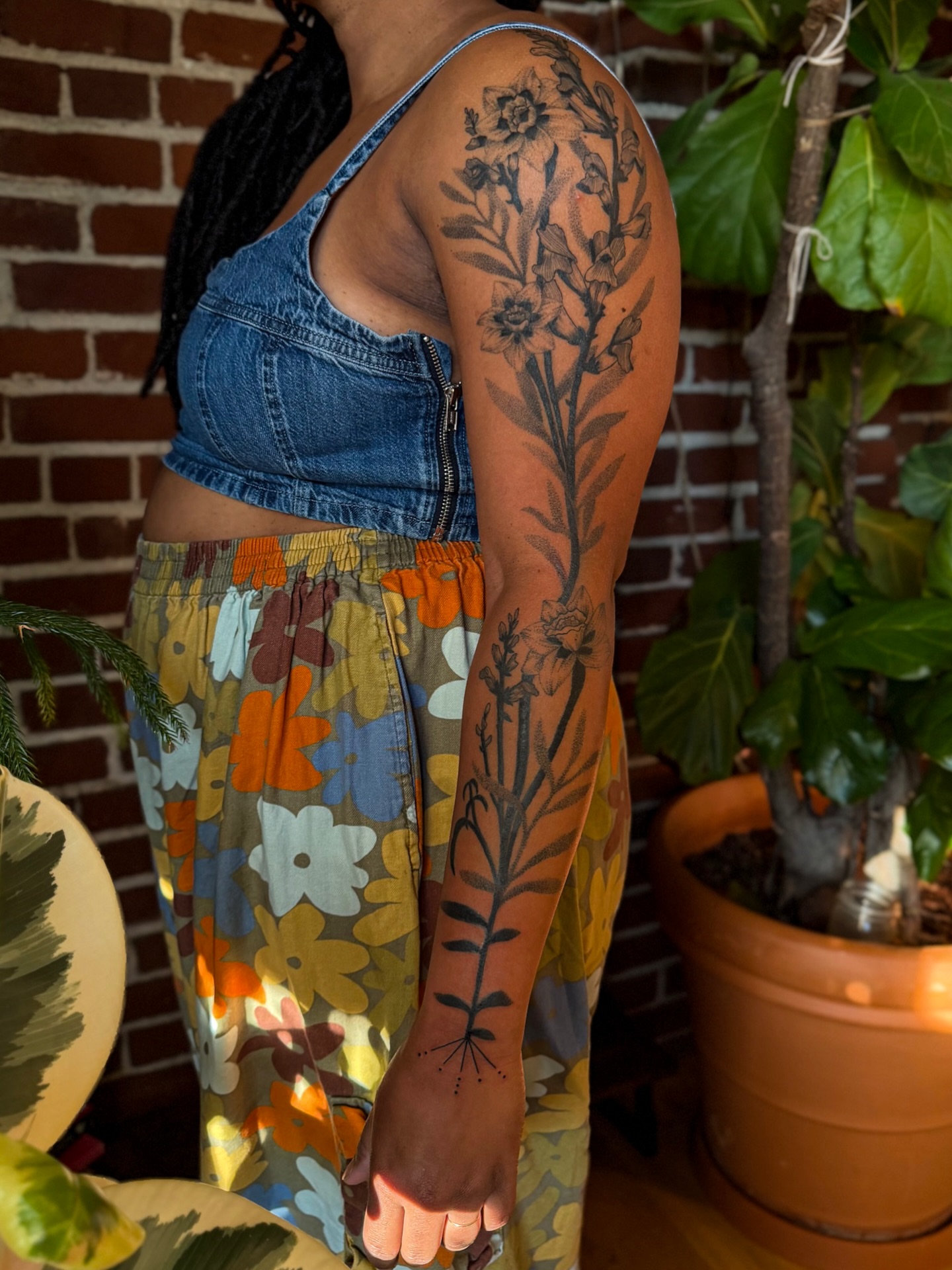 Floral plant black and grey tattoo on the upper arm by Alexandra Gray