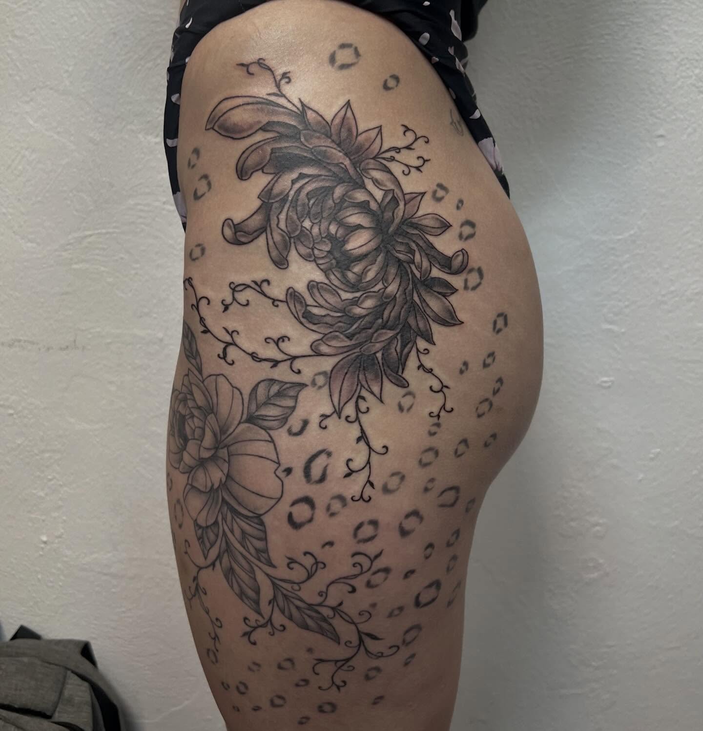 Floral bouquet black and grey tattoo on the thigh by Amber Rose